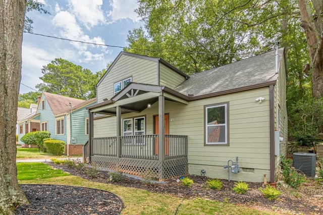 view of front of house featuring central AC unit, covered porch, roof with shingles, crawl space, and a front yard