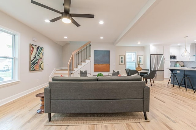 living room featuring light wood-style flooring, recessed lighting, stairway, and baseboards