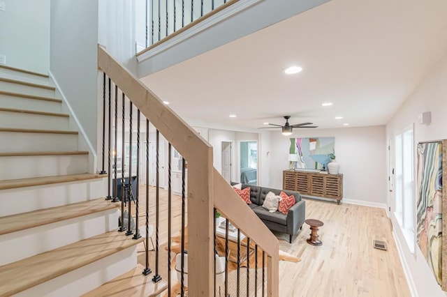 staircase featuring baseboards, wood finished floors, visible vents, and recessed lighting