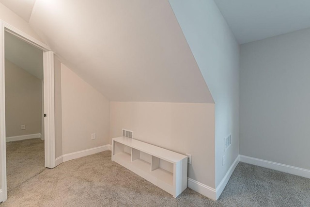 additional living space featuring lofted ceiling, carpet flooring, visible vents, and baseboards