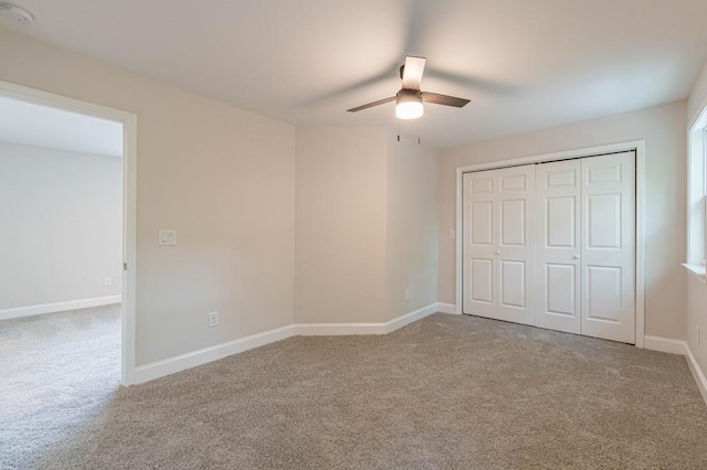 unfurnished bedroom featuring carpet, a closet, ceiling fan, and baseboards