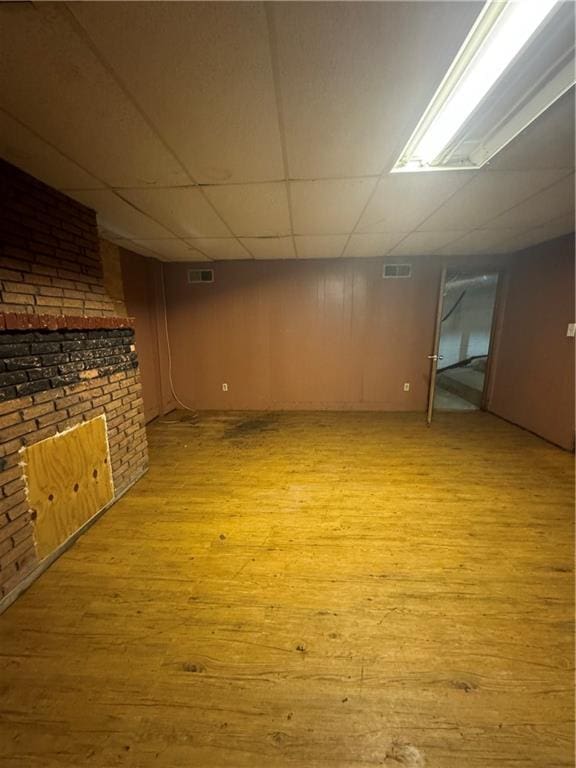 basement with light wood-type flooring and a drop ceiling