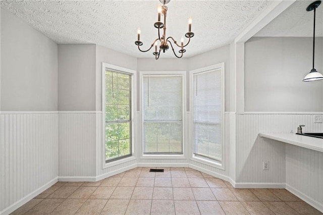 94 Park Ave W, Dallas, GA 30157 - unfurnished dining area featuring a chandelier, tile patterned flooring, a wainscoted wall, and a textured ceiling