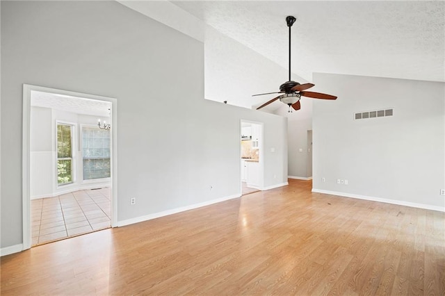 94 Park Ave W, Dallas, GA 30157 - unfurnished living room featuring a ceiling fan, high vaulted ceiling, a chandelier, and light wood finished floors