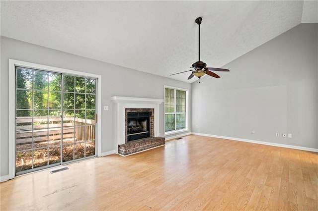 94 Park Ave W, Dallas, GA 30157 - unfurnished living room featuring a textured ceiling, light wood finished floors, a ceiling fan, lofted ceiling, and a brick fireplace
