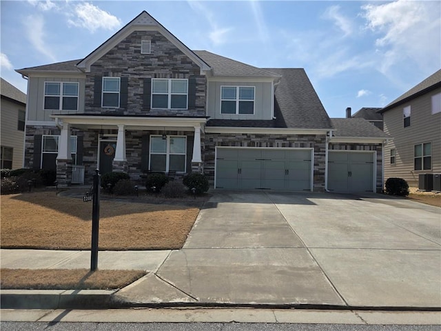 craftsman inspired home with a porch, stone siding, driveway, and a shingled roof