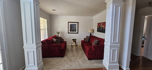 living room with hardwood / wood-style flooring, crown molding, and decorative columns