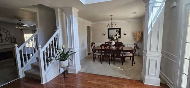 dining area with ceiling fan with notable chandelier, dark hardwood / wood-style floors, and crown molding