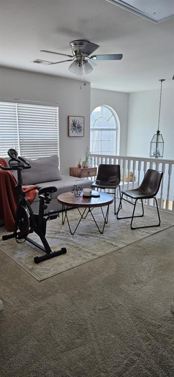 carpeted living room featuring ceiling fan