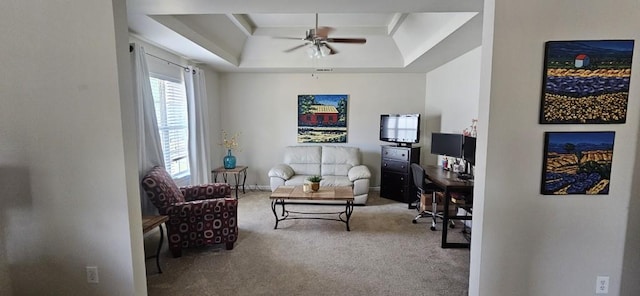 sitting room with light colored carpet, ceiling fan, and a raised ceiling