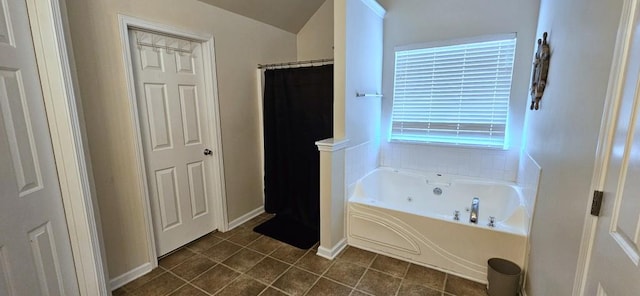 bathroom with shower with separate bathtub, vaulted ceiling, and tile patterned floors