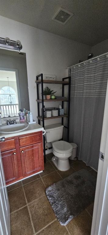 bathroom featuring curtained shower, a textured ceiling, vanity, and toilet