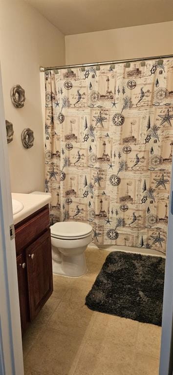 bathroom with tile patterned flooring, curtained shower, vanity, and toilet