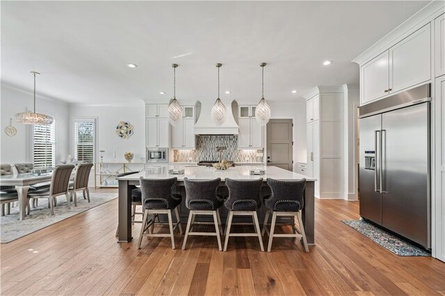 109 Owens Mill Pl, Canton, GA 30115 - kitchen with backsplash, light countertops, a spacious island, built in appliances, and custom range hood