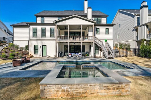 109 Owens Mill Pl, Canton, GA 30115 - back of house at dusk with a balcony, a ceiling fan, fence, an in ground hot tub, and stairs