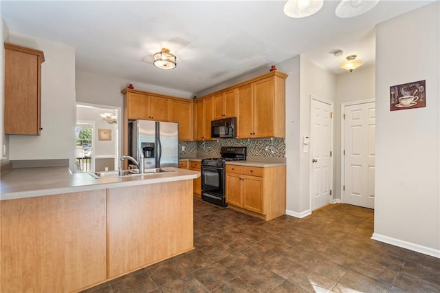 kitchen featuring backsplash, black appliances, kitchen peninsula, and sink