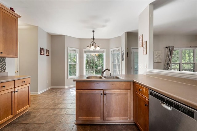 kitchen with hanging light fixtures, sink, kitchen peninsula, stainless steel dishwasher, and an inviting chandelier