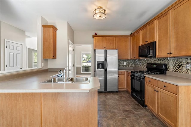 kitchen with black appliances, kitchen peninsula, a healthy amount of sunlight, and sink