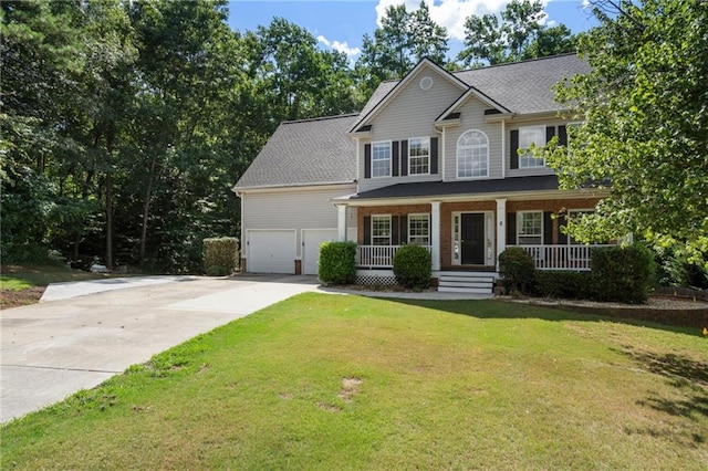 view of front of property with a front lawn, covered porch, and a garage