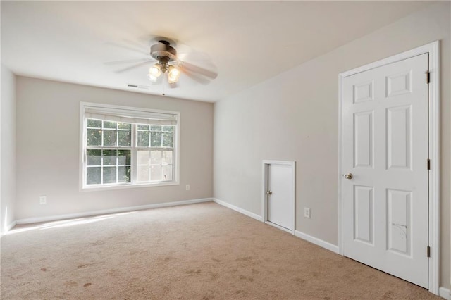 carpeted spare room featuring ceiling fan