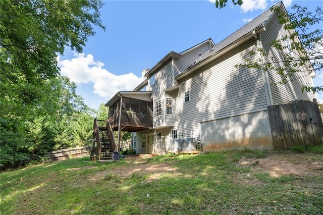 back of house featuring a sunroom and a yard