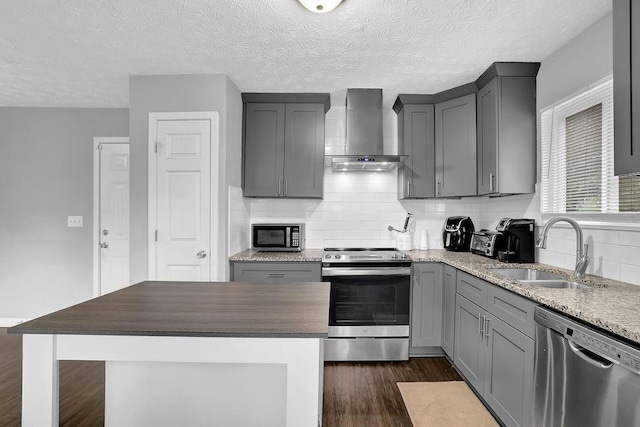 5461 Forest Path Ct, Stone Mountain, GA 30088 - kitchen with stainless steel appliances, wall chimney exhaust hood, a sink, gray cabinetry, and dark wood finished floors