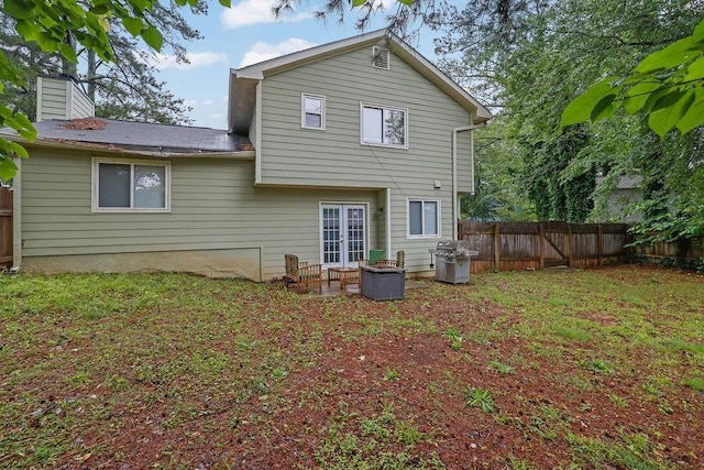5461 Forest Path Ct, Stone Mountain, GA 30088 - back of property with a fenced backyard, a chimney, french doors, and a patio