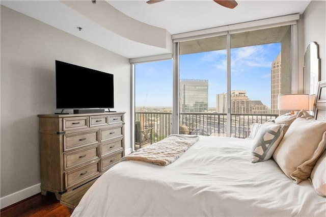 bedroom with dark wood-style flooring, floor to ceiling windows, a ceiling fan, access to outside, and baseboards