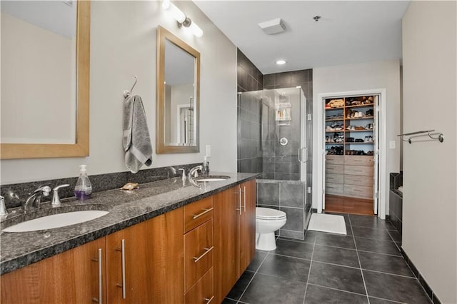 bathroom with double vanity, tile patterned flooring, a sink, and a shower stall