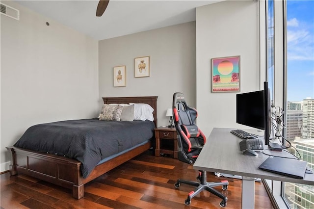 bedroom with a ceiling fan, visible vents, and wood finished floors