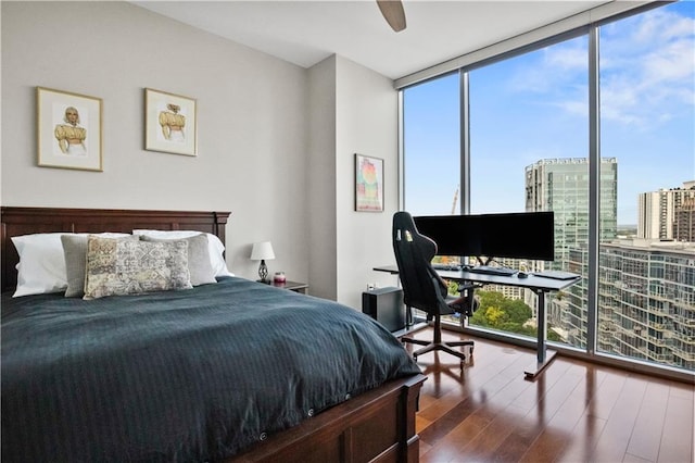 bedroom with expansive windows and wood finished floors