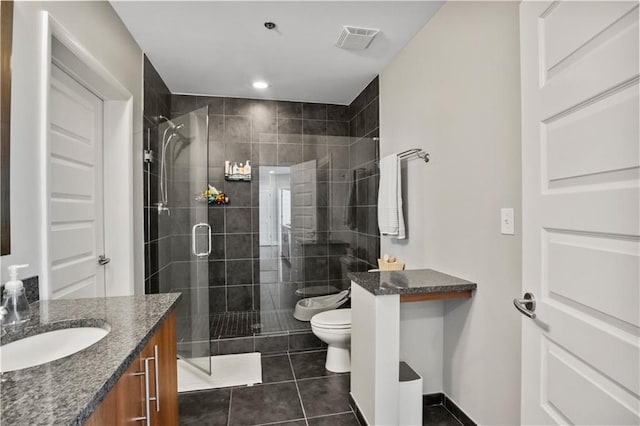 bathroom featuring toilet, visible vents, vanity, tile patterned floors, and a stall shower