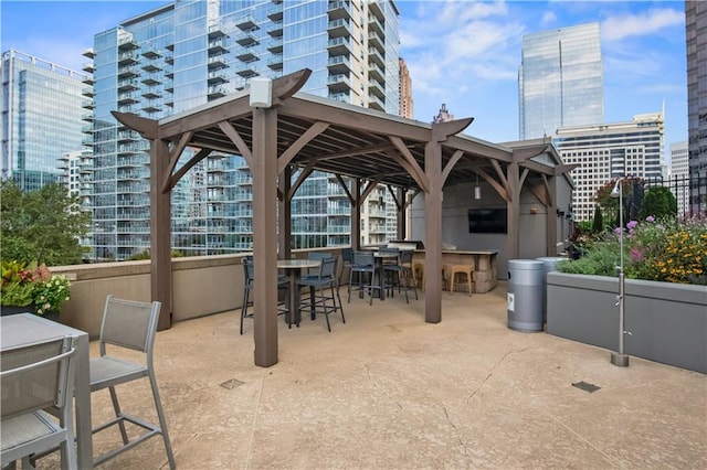 view of patio / terrace featuring a view of city, outdoor dry bar, and a gazebo