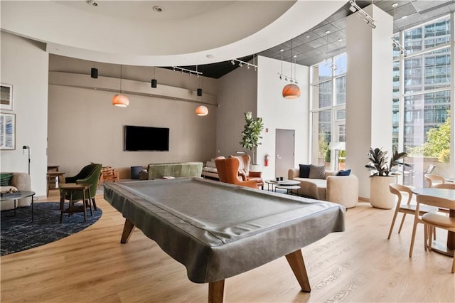 recreation room with a wall of windows, wood finished floors, and a wealth of natural light