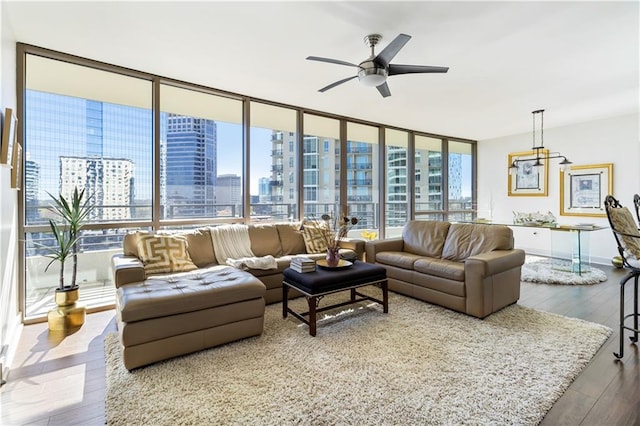 living room with hardwood / wood-style floors, a wall of windows, and ceiling fan