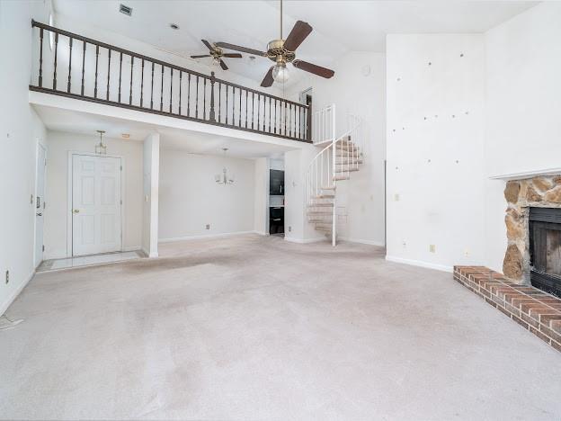 904 Bridge Ln SE, Smyrna, GA 30082 - unfurnished living room featuring high vaulted ceiling, a fireplace, a ceiling fan, stairway, and carpet floors