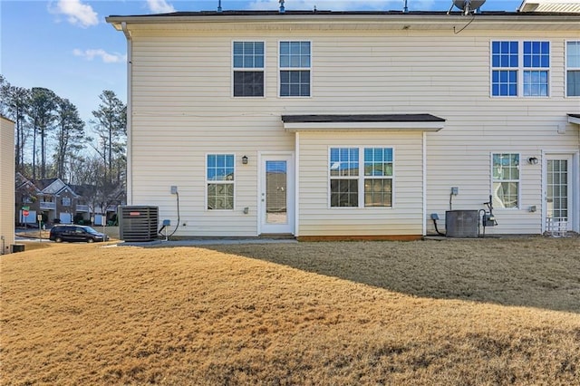 back of house featuring cooling unit and a lawn