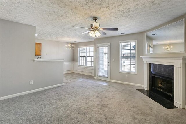 unfurnished living room with a tiled fireplace, a textured ceiling, light carpet, and a wealth of natural light