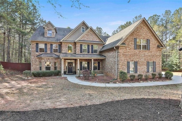craftsman inspired home with fence and brick siding