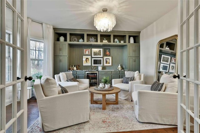 sitting room featuring a chandelier, a bar, wine cooler, and french doors
