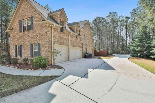 view of home's exterior featuring brick siding, driveway, and a garage