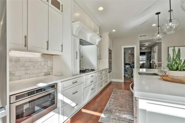 kitchen featuring ventilation hood, a sink, visible vents, recessed lighting, and decorative backsplash