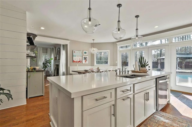 kitchen featuring light countertops, plenty of natural light, a sink, and wine cooler