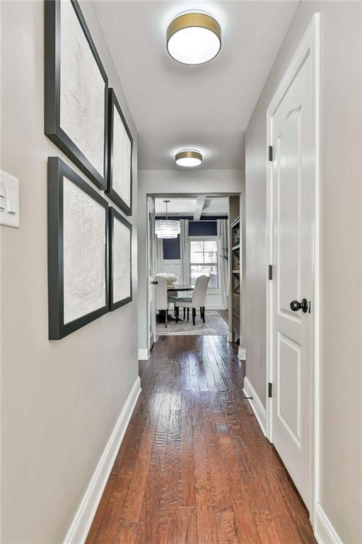 hallway featuring hardwood / wood-style floors and baseboards
