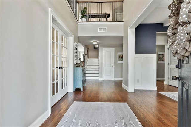 foyer with wood-type flooring, stairway, visible vents, and french doors