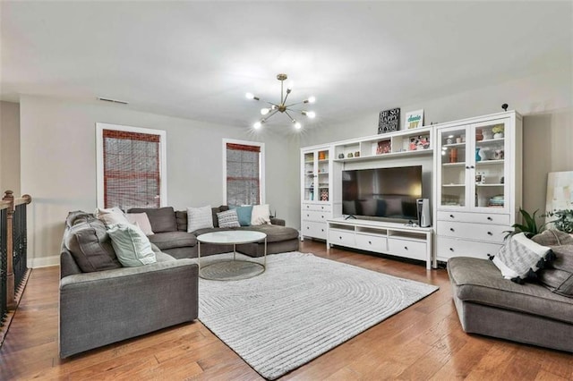 living room with an inviting chandelier, wood finished floors, and visible vents