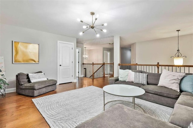 living room with a chandelier, wood finished floors, and baseboards