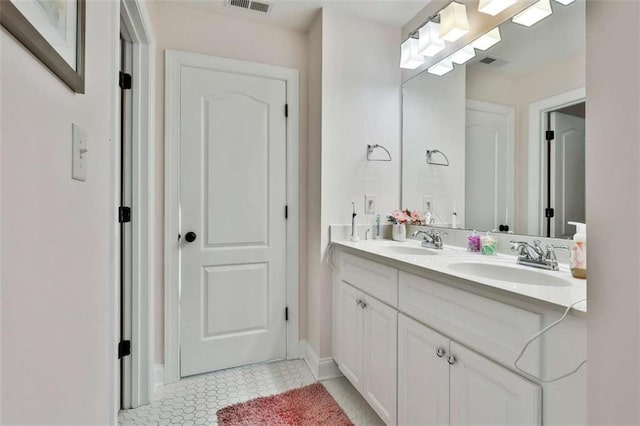 full bathroom with tile patterned flooring, baseboards, a sink, and double vanity