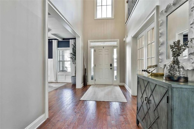entrance foyer featuring baseboards, a high ceiling, and dark wood-style floors