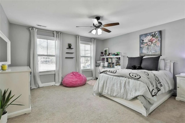 bedroom with light carpet, baseboards, visible vents, and ceiling fan